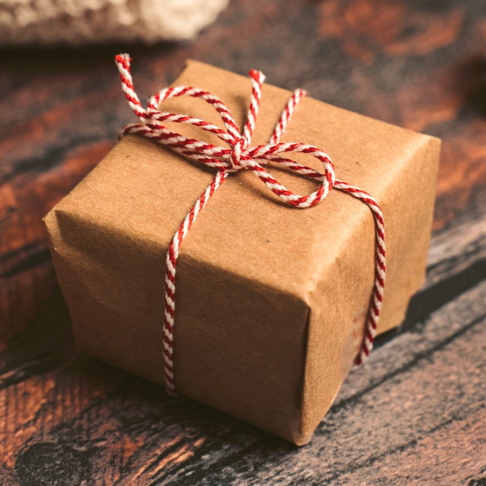 box wrapped in kraft paper tied with red and white string