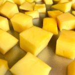 mango chunks on baking sheet ready to freeze